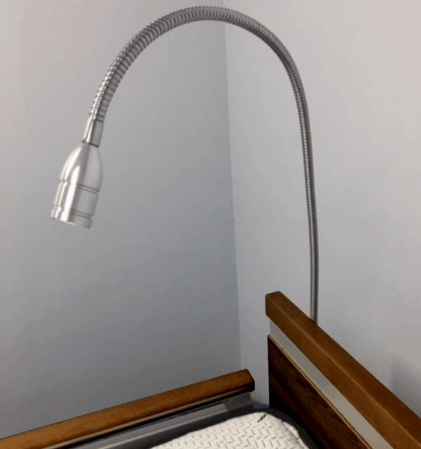 a bed with a lamp on top of it.