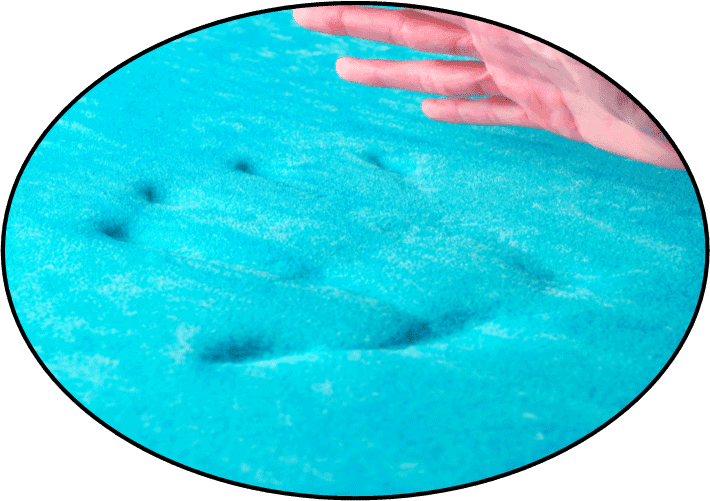 a person's hand is touching a blue substance.