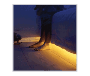 a person standing on a wooden floor next to a bed.