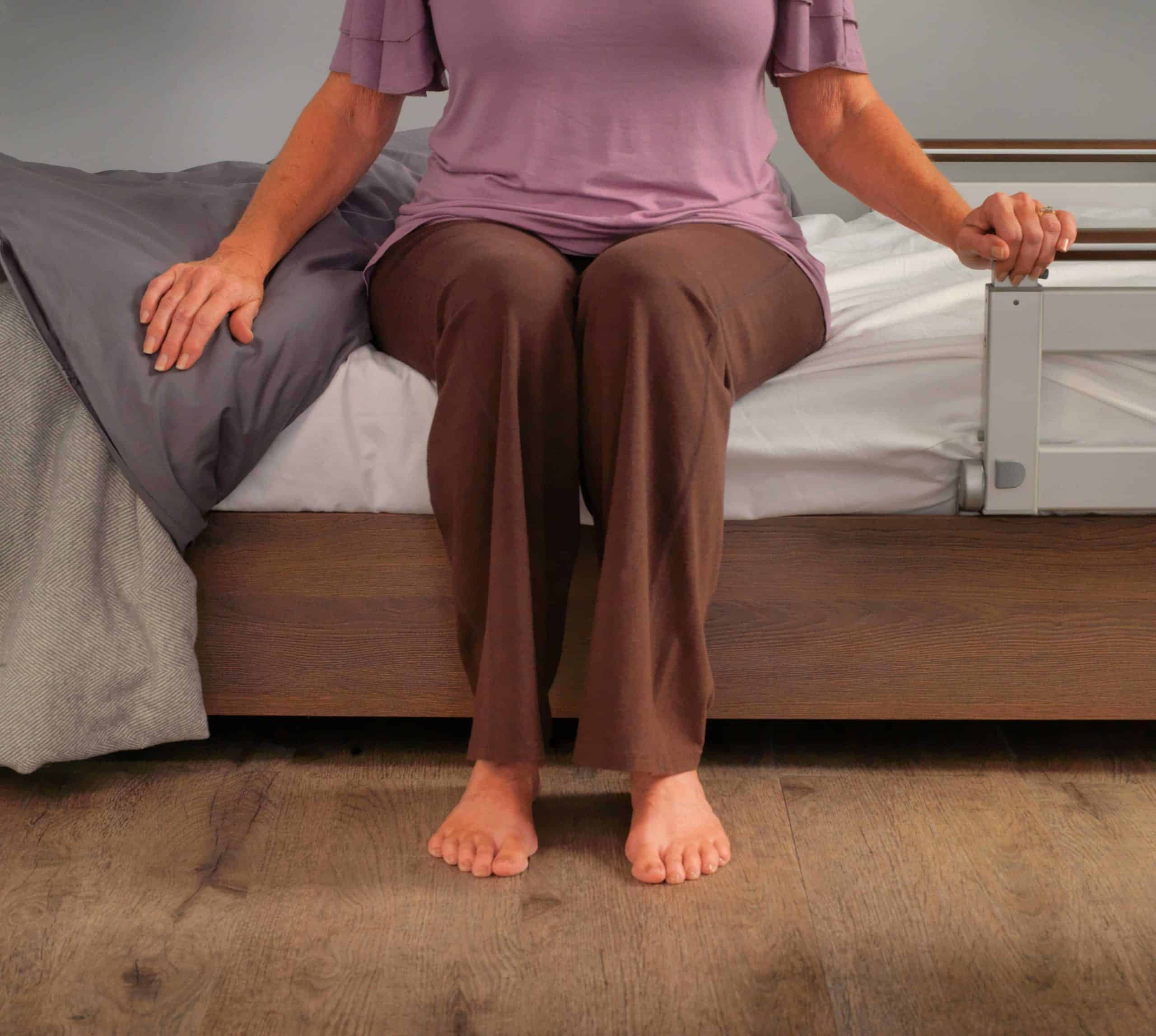 a woman sitting on a bed with her legs crossed.