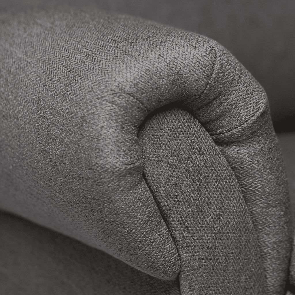 a close up of a gray couch with a black and white background.