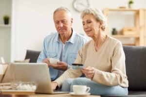 An older couple using a laptop at home shopping for hospital beds for home