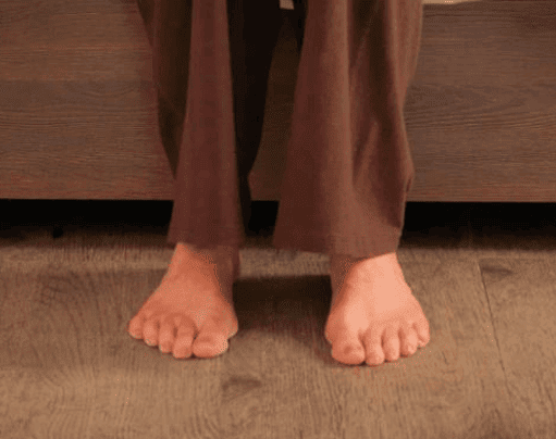 A person's feet on an Aura Platinum 39 Upwork bed.