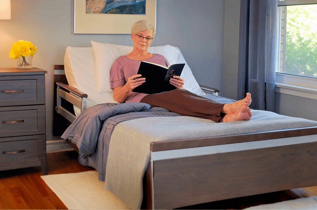 A woman is sitting on a bed reading a book.