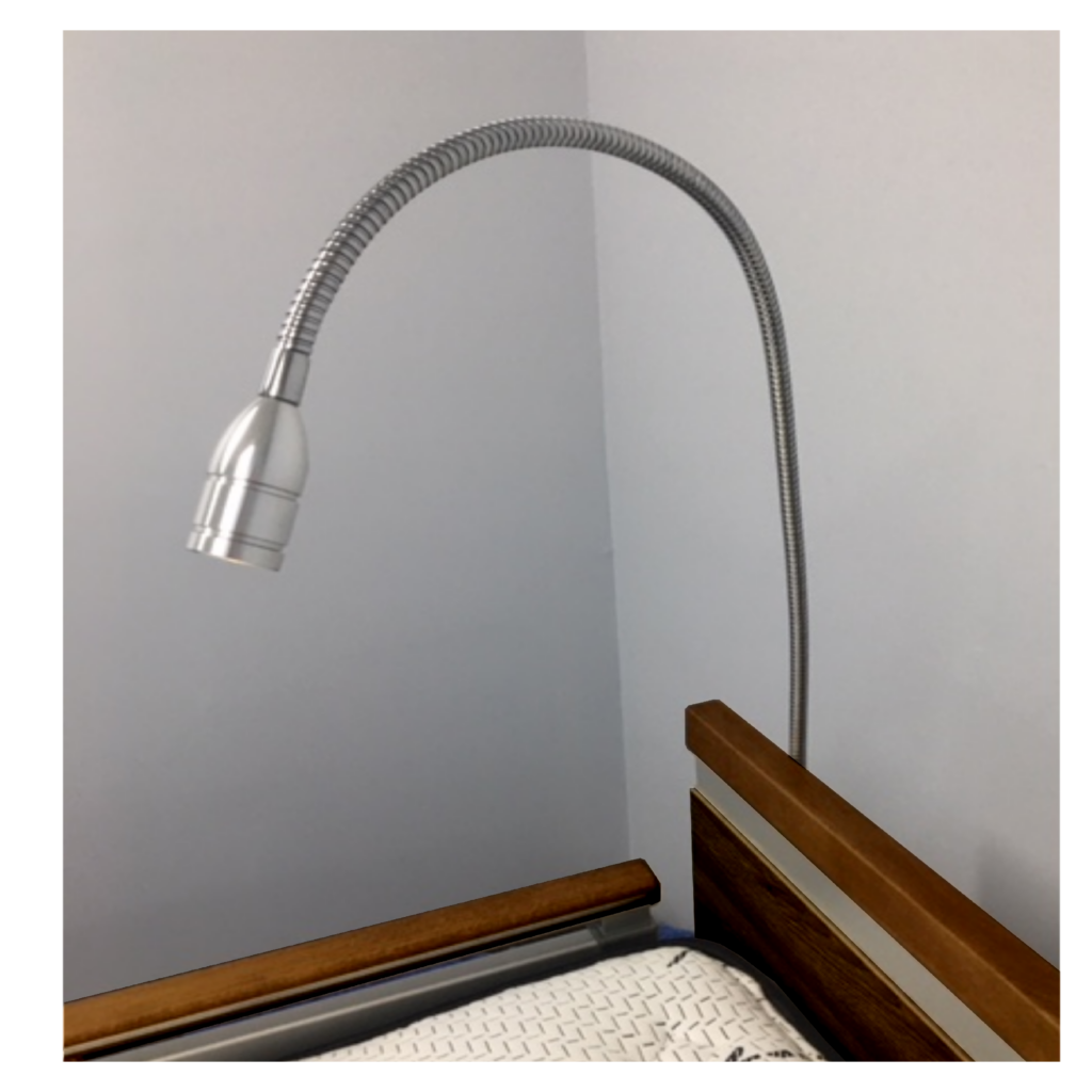 A flexible desk lamp, #15395, overhanging a wooden bedside table against a grey wall.