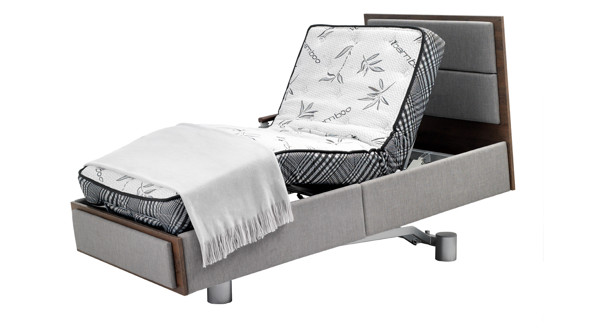 A modern adjustable bed with a floral patterned mattress, extended footrest, wooden side panels, and a draped gray blanket.