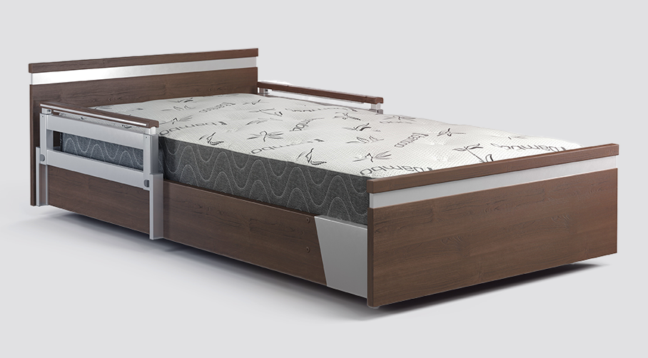 Wooden hospital bed with metal rails, featuring a white and gray patterned mattress.