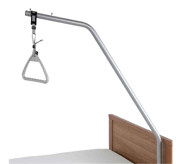 Hospital bed trapeze with a triangular handle attached to a metal frame, positioned over a bed with a wooden headboard.