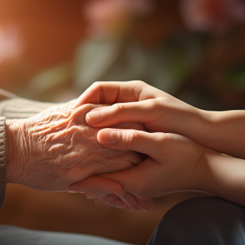 A woman holding an elderly person's hand.